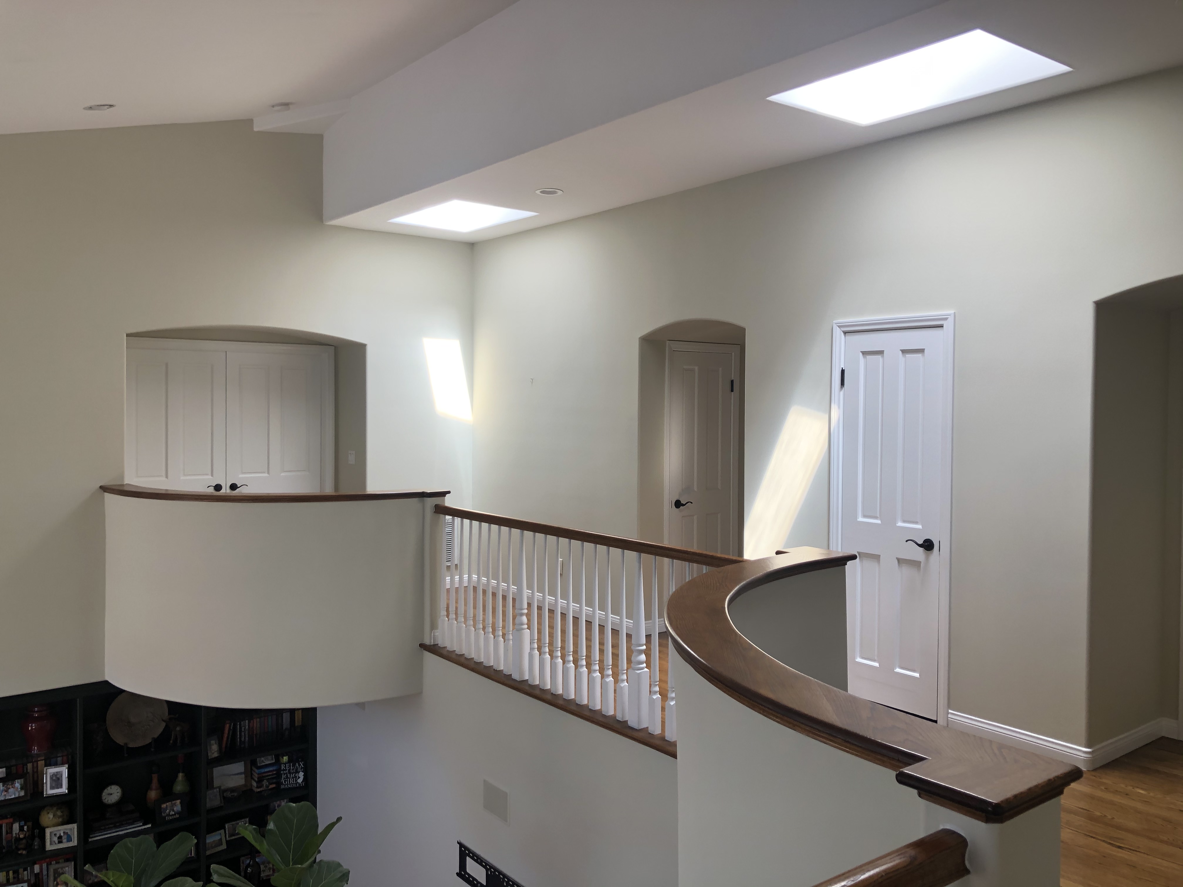 Interior landing with white railings and skylights